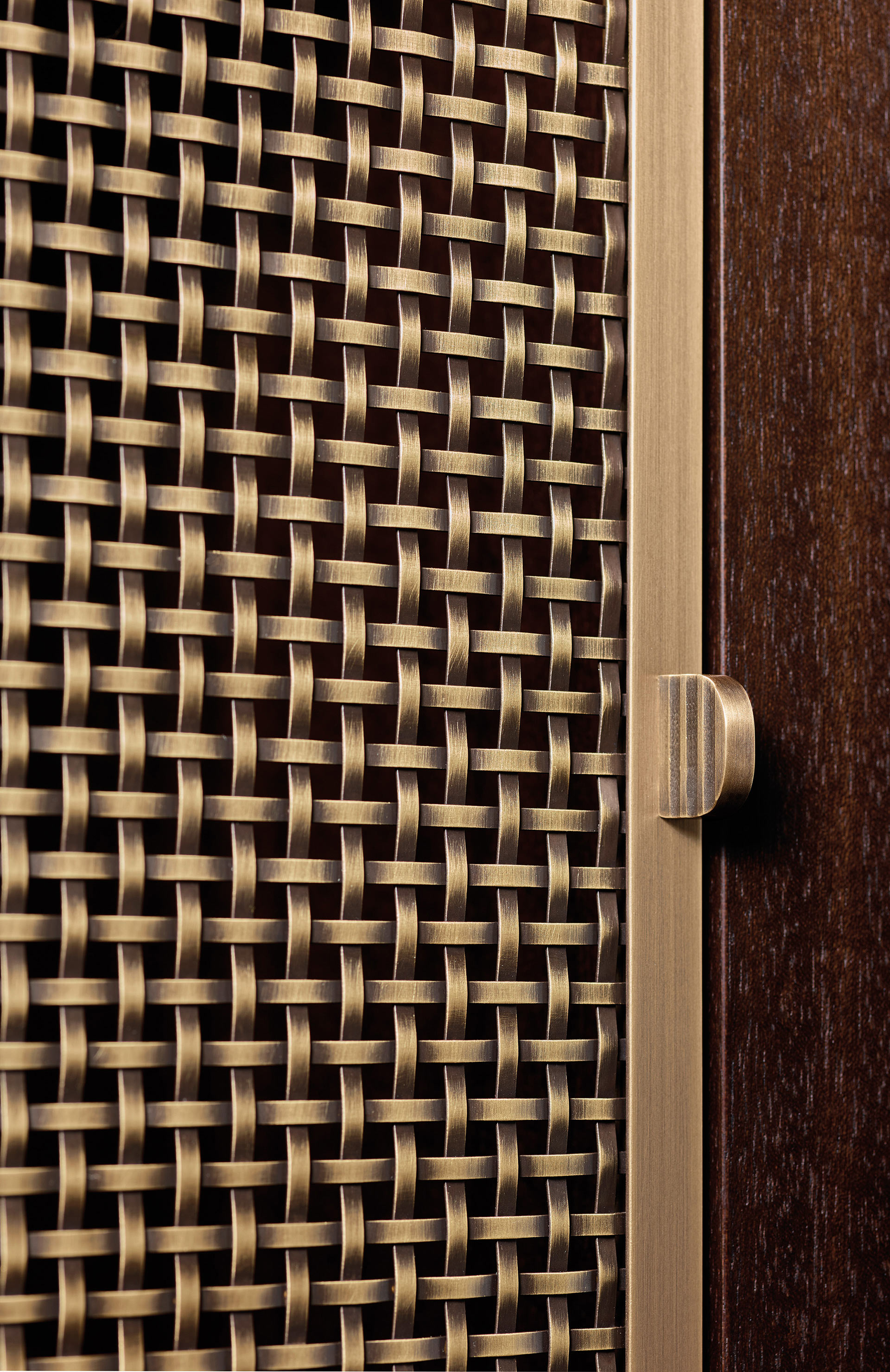 Detail of the bronze handle of Nightwood, a wooden modular bookcase with bronze details, from Promemoria's Night Tales collection | Promemoria