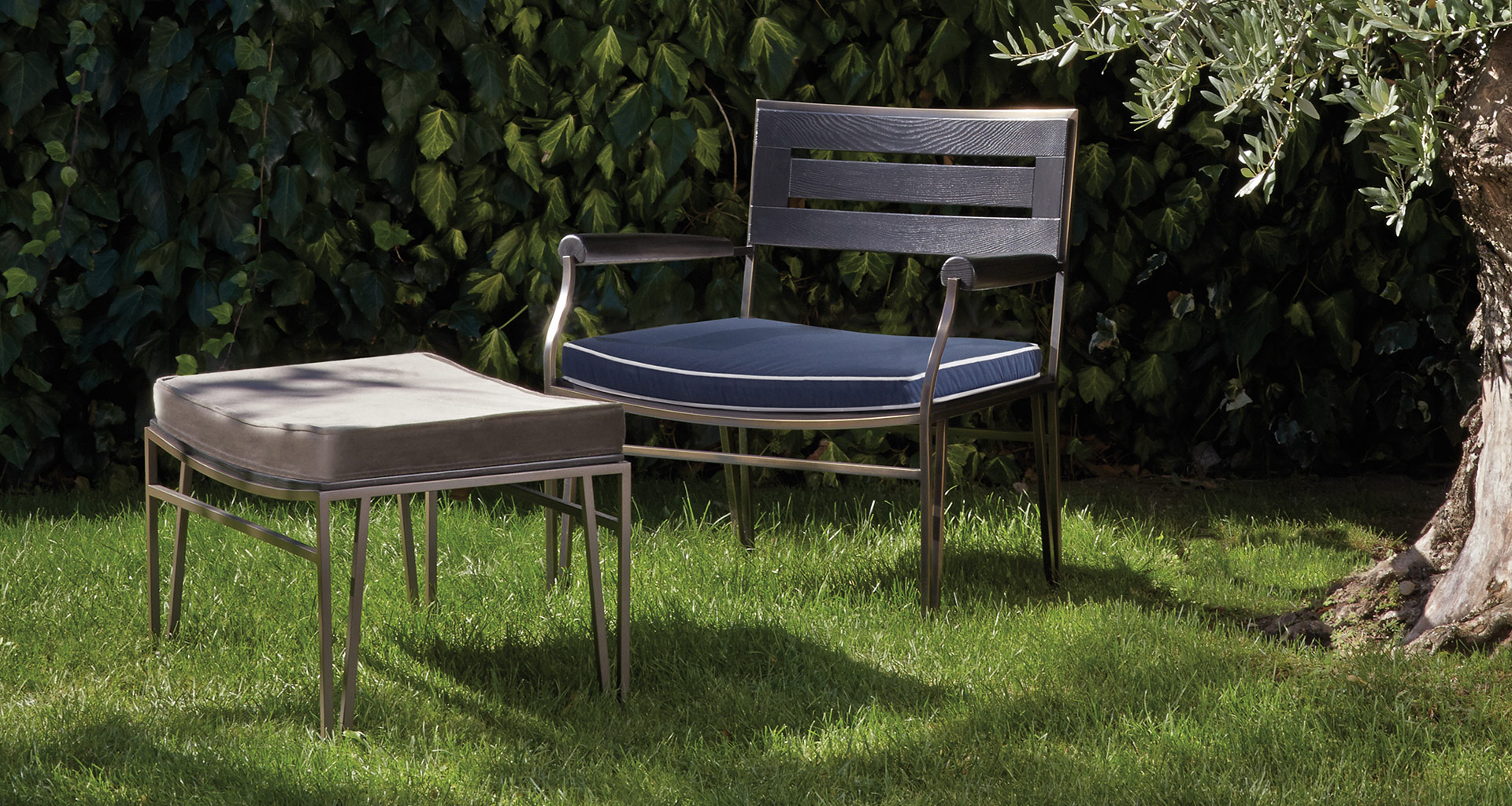 Cernobbio is a wooden and bronze armchair and pouf with fabric cushion, from Promemoria's outdoor catalogue | Promemoria